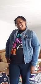 photo of community member standing and smiling with a denim jacket