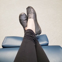  A lupus patient's feet crossed, sitting in a chair getting an infusion