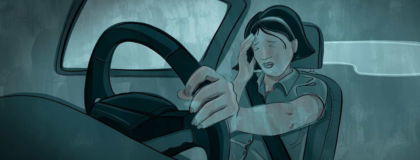 A woman behind the steering wheel of a car clutches her head and winces her eyes.