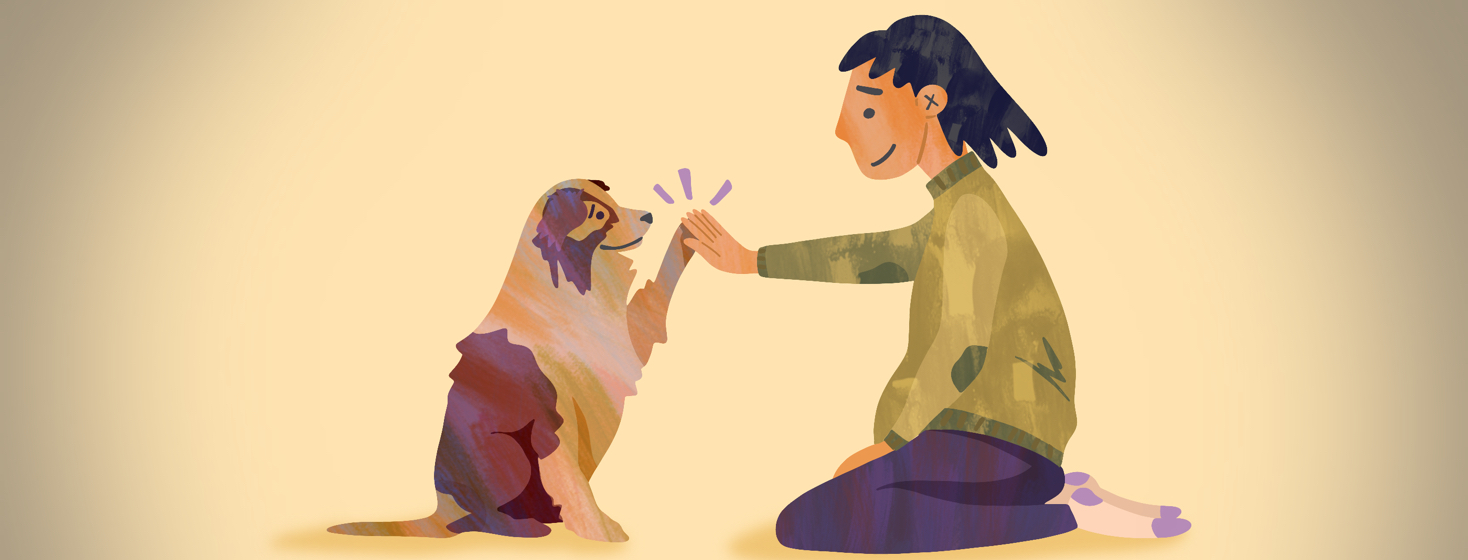 A woman kneels down and gives her cute dog a high five.