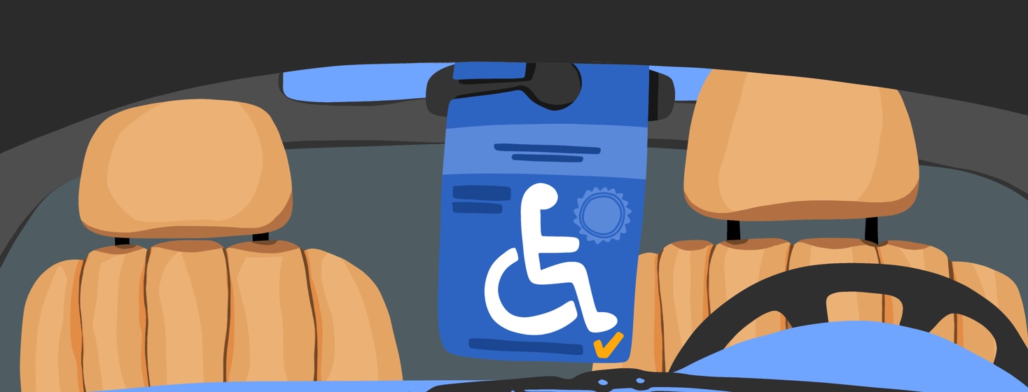A look at the inside of a car, showing a handicapped tag hanging from the rearview mirror.
