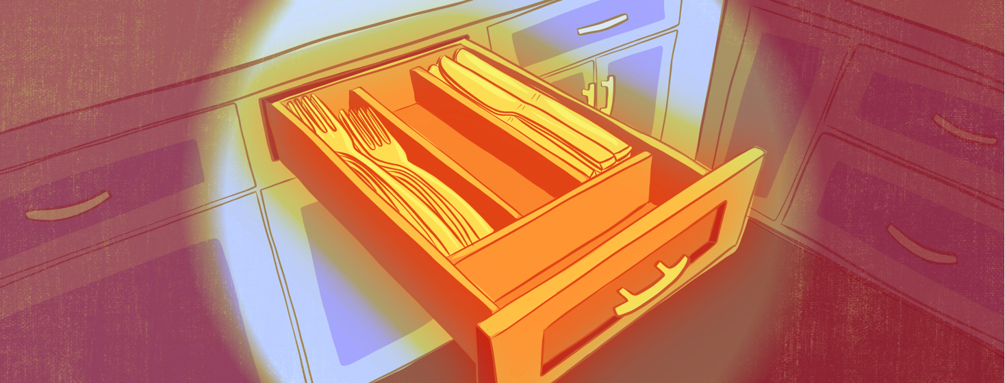 A drawer with full sections of knives and forks but an empty spoon section.