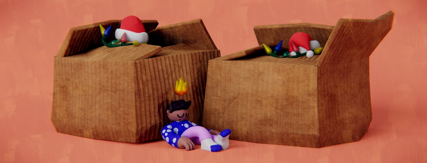 A nonbinary person is flopped on the floor, leaning up against a comically large cardboard boxes full of holiday decorations. Hovering above their head is a small fire or flare icon.
